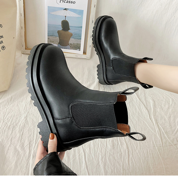 Black lug sole Chelsea boot held in hand