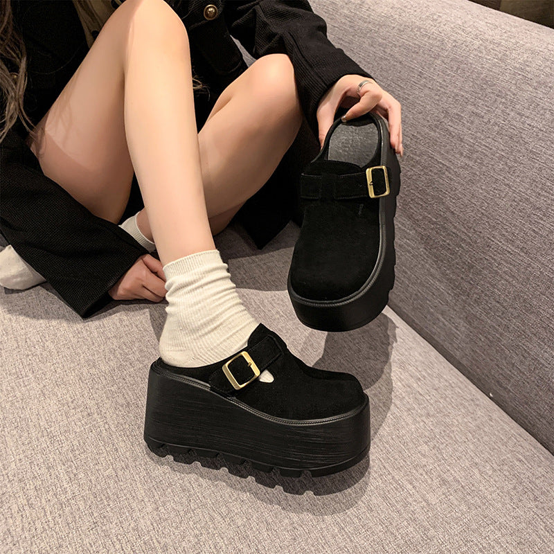 Black buckle platform clogs worn indoors