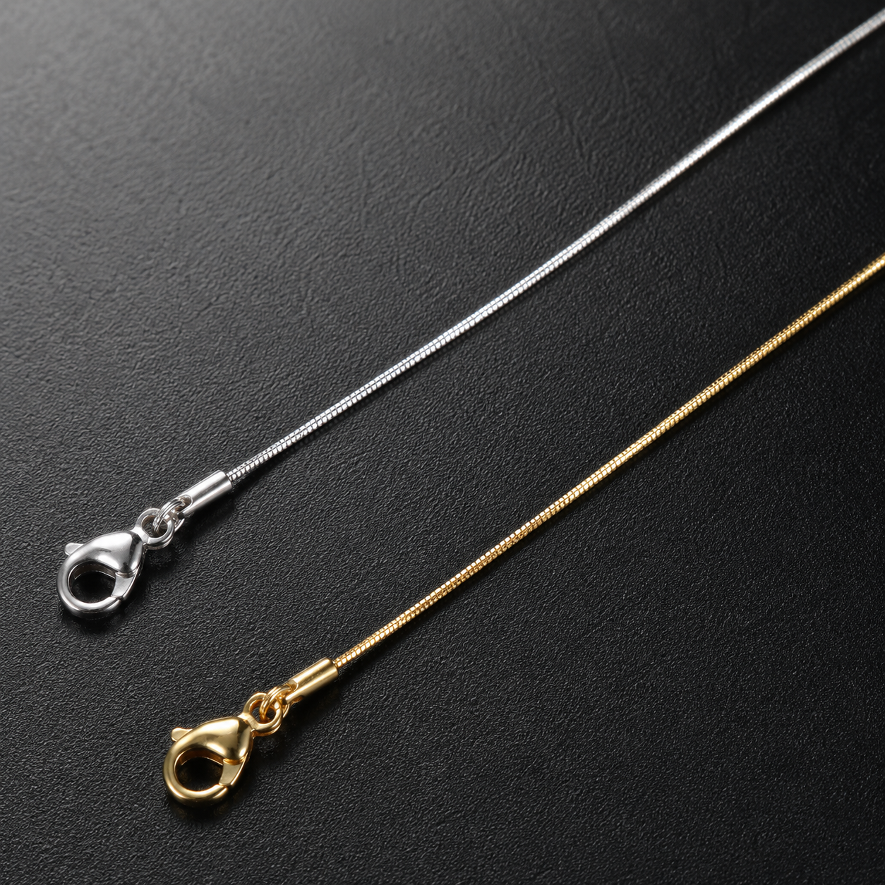 Silver and gold-tone 0.9mm square snake chain clasp detail